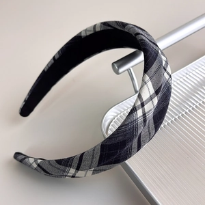 Close-up of French vintage black and white checkered fabric padded headband on display stand