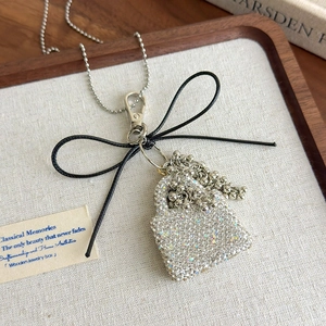 Detailed macro view of silver rhinestone handbag pendant with elegant beaded chain tassels
