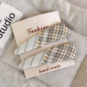 Close-up of olive green plaid fringe hair clips on fashion handmade display card