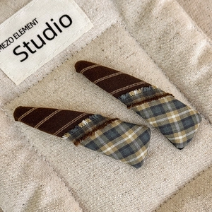 Detail of triangle plaid BB hair clips featuring fringed patchwork fabric and vintage texture