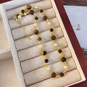 Collier élégant en œil de tigre et perles avec perles dorées sur une boîte à bijoux