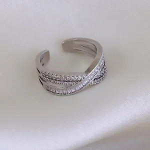 Crossed silver adjustable ring with baguette and round cubic zirconia stones
