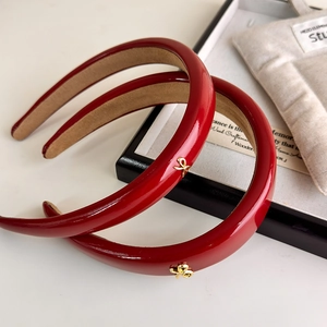 Macro shot of red leather headbands featuring gold bow details and velvet lining