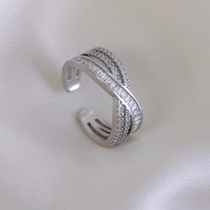 Detail of luxury crisscross open ring with shimmering cubic zirconia on silk background