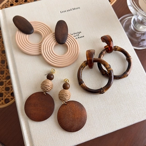 Detailed view of Bohemian wooden hoop earrings with woven straw and resin accents
