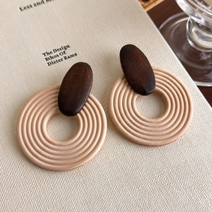 Detailed close-up of Bohemian wood and resin round earrings with textured circular pattern