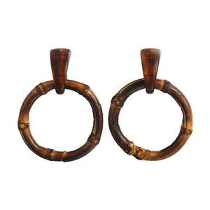 Detailed macro view of bohemian wood earrings with amber resin texture and bamboo joints