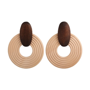 Detail of bohemian wood earrings with concentric circular textures and brown geometric design