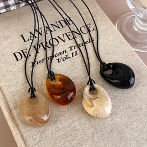 Irregular resin pendant necklaces in amber and marble patterns for autumn minimalist style