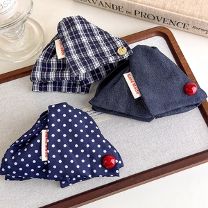 Detail of navy blue plaid and polka dot fabric shark clips with red buttons and handmade label