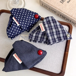 Three handmade navy blue plaid and polka dot fabric hair claw clips in a wooden tray