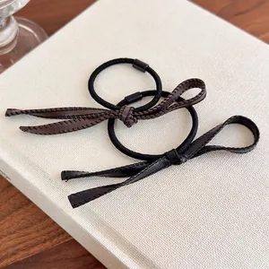 Élastiques à cheveux vintage en cuir PU marron et noir style français sur un livre