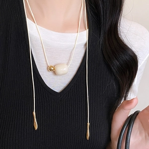 Ivory bead pendant necklace with minimalist gold accents on a long cord cord style