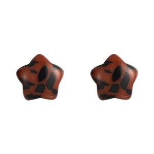 Macro view of leopard print star stud earrings made from brown and black resin material