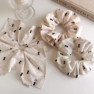 Vue détaillée de chouchous à pois beige et un nœud sur une surface blanche
