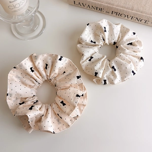 Lot de chouchous beiges avec pois noirs et nœuds sur fond esthétique minimaliste