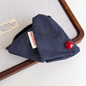 Detail of handmade navy blue plaid fabric hair claw clip with red button and label