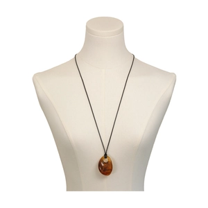 Irregular amber-toned pendant necklace on minimalist black cord worn on a white bust