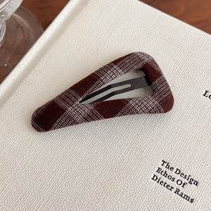 Detailed close-up of a brown plaid fabric covered triangular BB hair clip for women