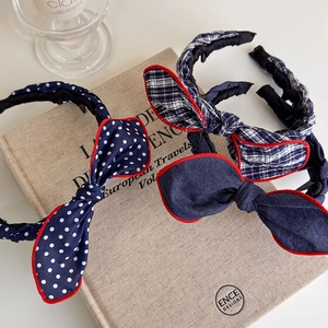 Close-up of three knot headbands featuring polka dots, plaid, and denim with red stitching