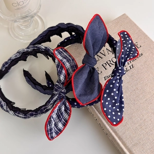 Detail of navy polka dot and plaid bow headbands with non-slip teeth and red piping
