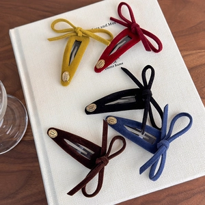 Five-piece velvet bow hair clips set with gold smile charms on a decorative book