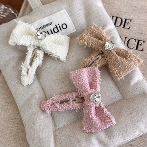 Set di tre fermagli per capelli con fiocchi di peluche e strass a cuore in colori tenui
