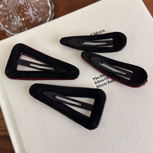 Detail of 4pcs retro velvet and red leather geometric BB hair clips on white book base