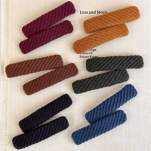 Detailed view of six pairs of knit-wrapped rectangular hair clips in rich autumn colors