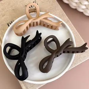 Dreiteiliges Set matter Haarklammern mit Schleife in Beige, Braun und Schwarz auf einem Tablett