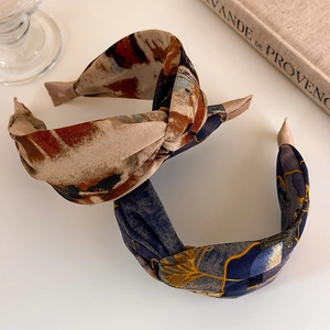 Close-up of retro twist knot headbands with abstract oil painting and ginkgo leaf prints