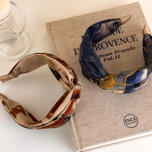 Detailed close-up of navy and beige tie-dye wide headbands with twisted knot texture