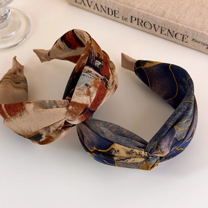 Close-up of vintage wide-brimmed cross-knot headbands with elegant tie-dye fabric texture