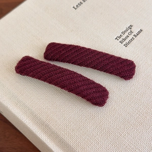Detail of dark wine red knitted rectangular hair clips with twill weave texture