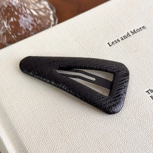Close-up of black triangle BB hair clip with snakeskin faux leather texture