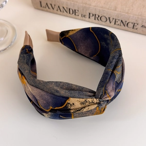 Detail of twisted wide headband with blue purple abstract print and gold line patterns