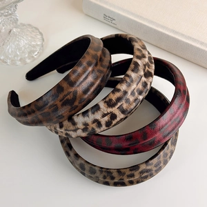Detail of four padded leopard print headbands in brown, wine red and cream faux leather textures