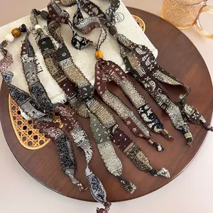 Gros plan de colliers bohèmes en tissu avec motifs cachemire et perles en bois chic