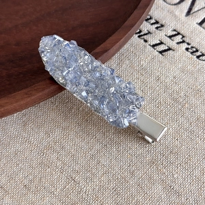 Vue rapprochée d'une pince à cheveux en cristal bleu clair avec base en métal argenté