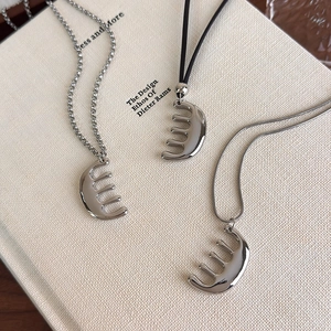 Détail de pendentifs peigne en argent avec chaînes à billes, cuir et serpent