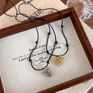 Adjustable pine cone pendant necklace with gold and silver finishes on black rope