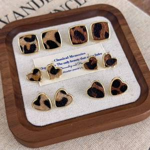 Détail de boucles d'oreilles léopard avec cadres dorés sur un plateau à bijoux raffiné