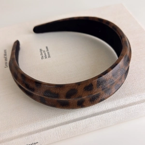 Detail of double-layered leopard print headband with retro texture on a white book