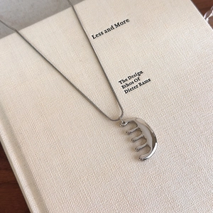 Détail d'un pendentif peigne créatif avec finition polie sur une chaîne serpent