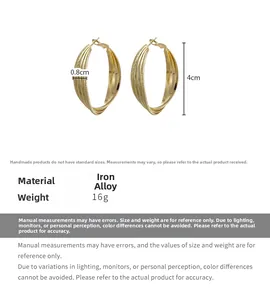 Macro detail of gold layered twisted hoop earrings with textured finish and 4cm dimensions