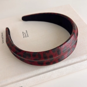 Detailed view of leopard print headband with red and black pattern on a designer book