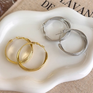 Twisted multi-layer hoop earrings in gold and silver finish with matte texture
