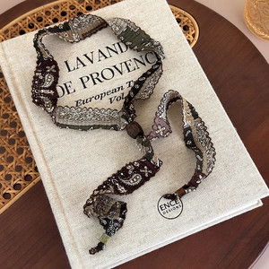 Détail du collier en tissu paisley avec bordure en dentelle et perles en bois