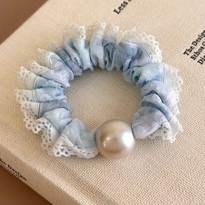 Detail of light blue gradient scrunchie with white lace trim and a large pearl ornament