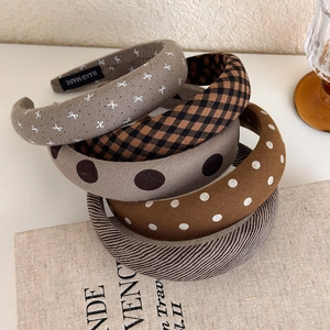 Detailed view of padded headbands featuring diverse brown patterns and handmade labels